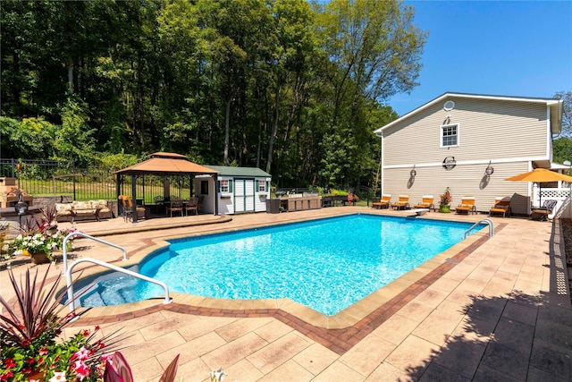 view of swimming pool featuring fence, a deck, a fenced in pool, and a gazebo