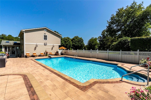 view of pool with a fenced in pool, a patio area, fence, and a diving board