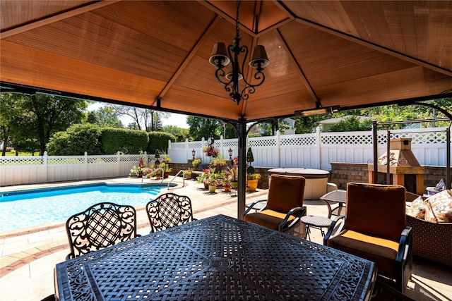 view of patio featuring a gazebo, a fenced in pool, a fenced backyard, and outdoor dining space