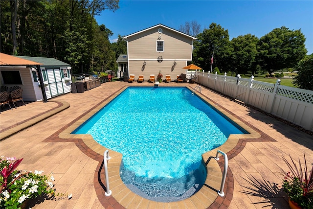 view of swimming pool with a fenced in pool, a patio area, fence, an outdoor structure, and a diving board