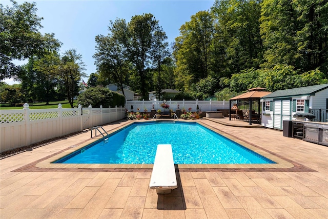 view of pool with a fenced in pool, a fenced backyard, an outdoor structure, a patio area, and a diving board