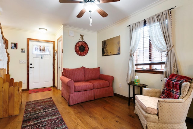 living area featuring stairway, ornamental molding, ceiling fan, wood finished floors, and baseboards