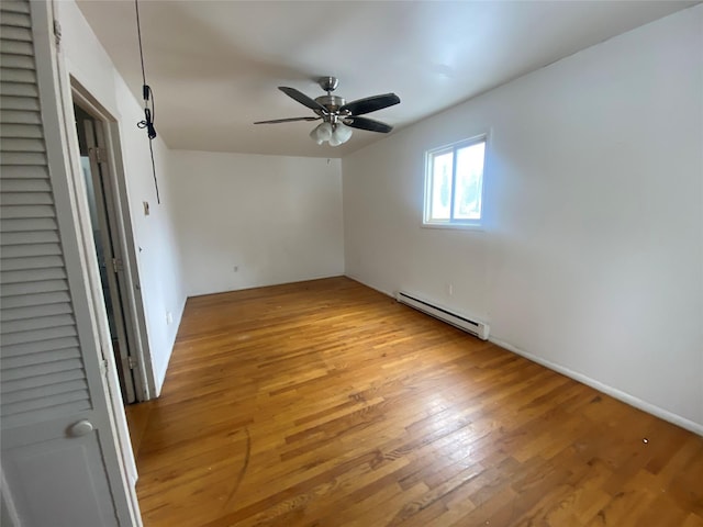 spare room with light wood-style flooring, baseboard heating, and a ceiling fan