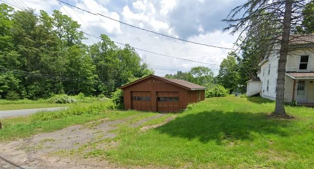 view of yard featuring a garage and an outdoor structure