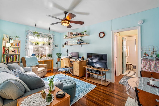 living area featuring wood finished floors, a ceiling fan, and baseboards