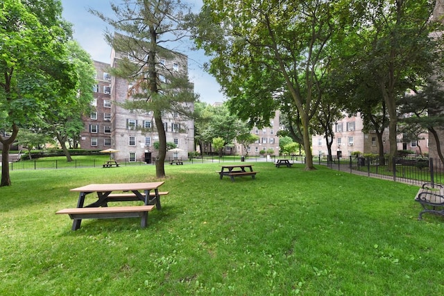 surrounding community with fence and a yard