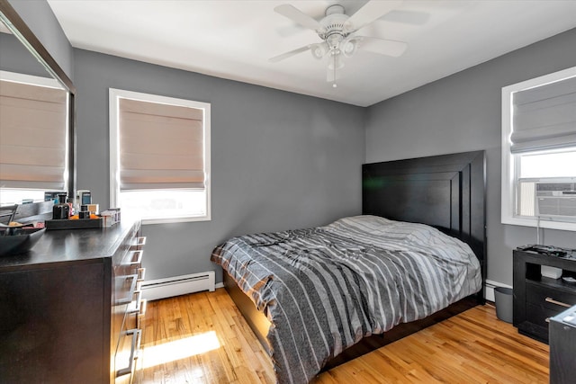 bedroom with light wood-style flooring, a baseboard radiator, baseboards, baseboard heating, and ceiling fan