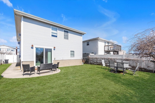 rear view of property with a patio, a lawn, and a fenced backyard