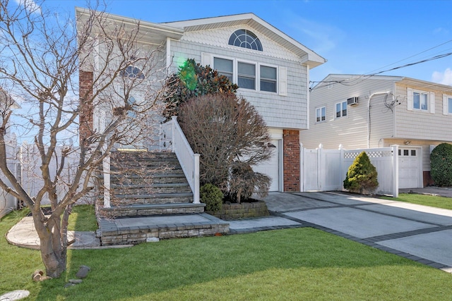 view of front facade with a front yard, fence, driveway, a garage, and brick siding