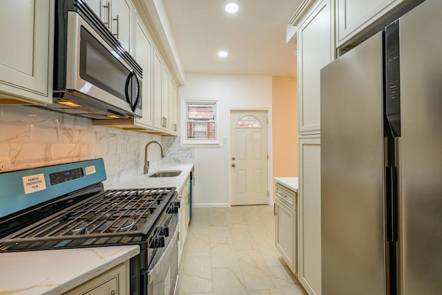 kitchen featuring tasteful backsplash, marble finish floor, stainless steel appliances, a sink, and recessed lighting