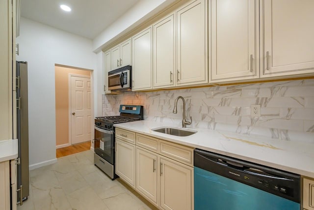 kitchen with stainless steel appliances, a sink, marble finish floor, backsplash, and light stone countertops