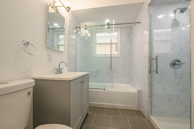 bathroom with combined bath / shower with glass door, vanity, and toilet