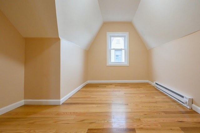 bonus room featuring lofted ceiling, baseboards, light wood-style flooring, and baseboard heating