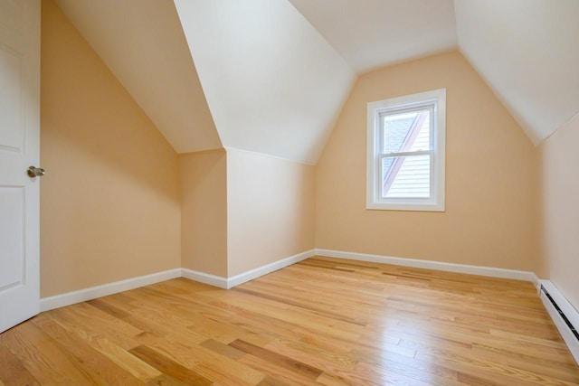 additional living space featuring light wood-type flooring, a baseboard radiator, and baseboards