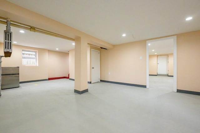 basement featuring fridge, recessed lighting, and baseboards