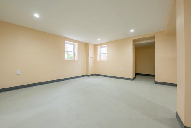 unfurnished room with recessed lighting, finished concrete flooring, and baseboards