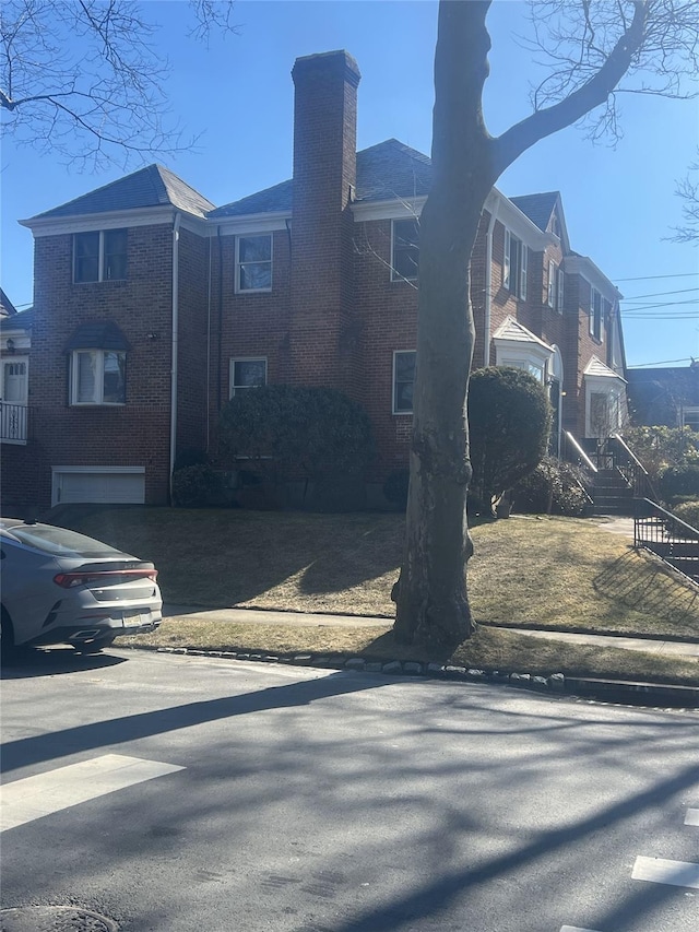 view of property exterior with brick siding and a chimney