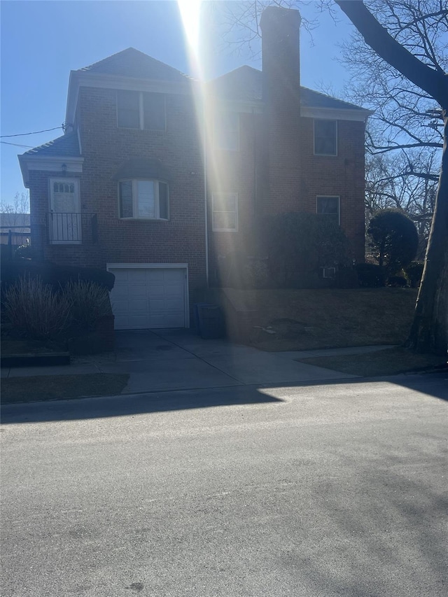 view of front of property with a garage, driveway, and a chimney