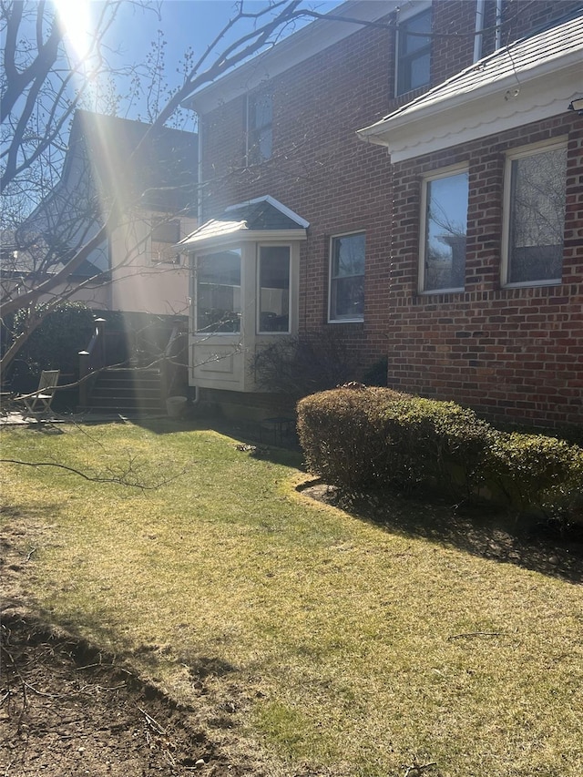 view of home's exterior featuring a lawn and brick siding