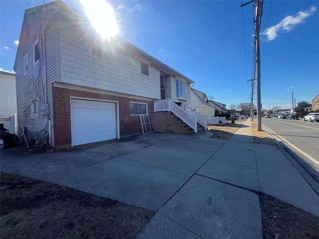 exterior space featuring concrete driveway and brick siding