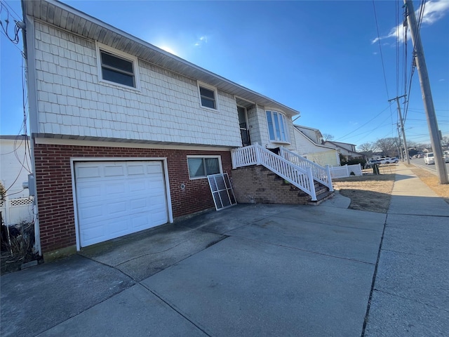 view of front of house with a garage, concrete driveway, and brick siding