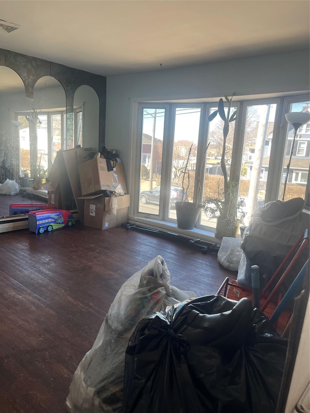 living area featuring visible vents and wood finished floors