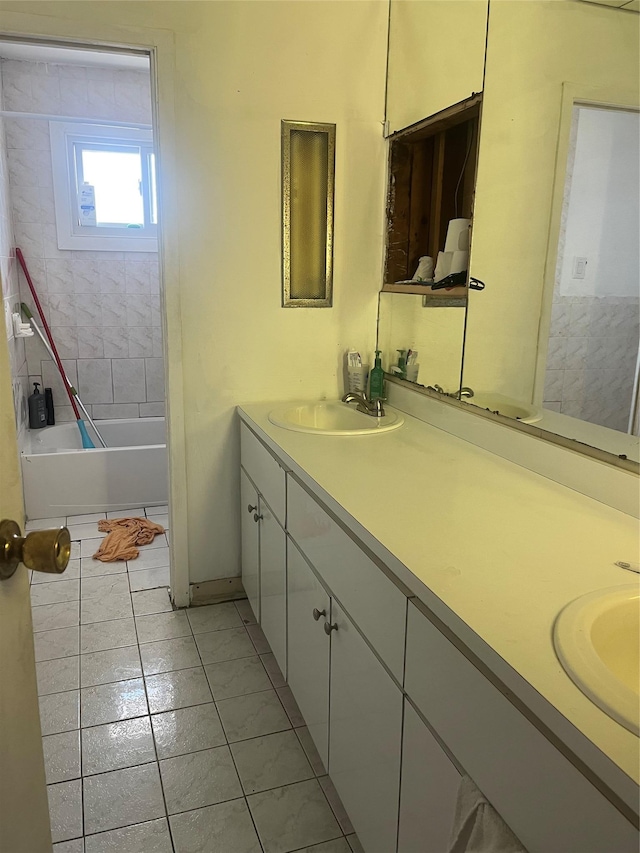 bathroom with a bathtub, tile patterned flooring, a sink, and double vanity