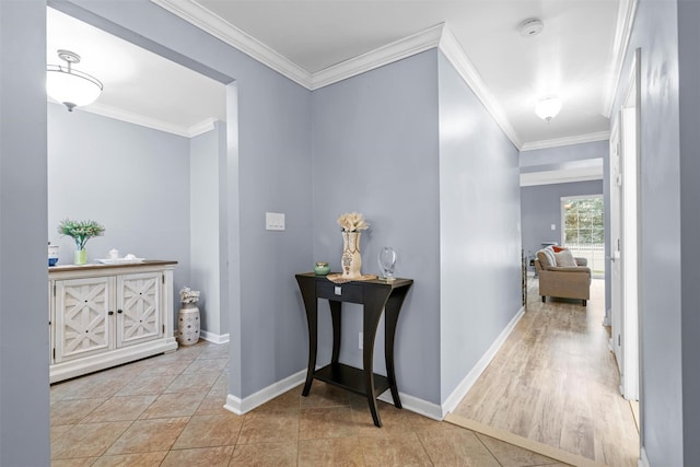 hallway with crown molding, baseboards, and tile patterned floors