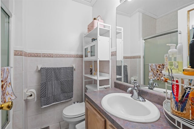 full bath with toilet, a shower with shower door, vanity, tile walls, and crown molding