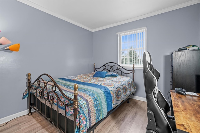 bedroom with baseboards, wood finished floors, and crown molding