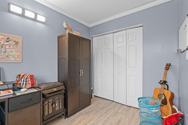 interior space with light wood finished floors, a closet, and crown molding