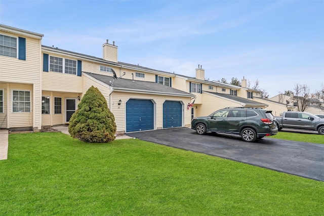 multi unit property featuring a garage, a front lawn, a chimney, and aphalt driveway