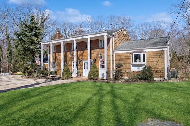 neoclassical / greek revival house with a front lawn and a chimney