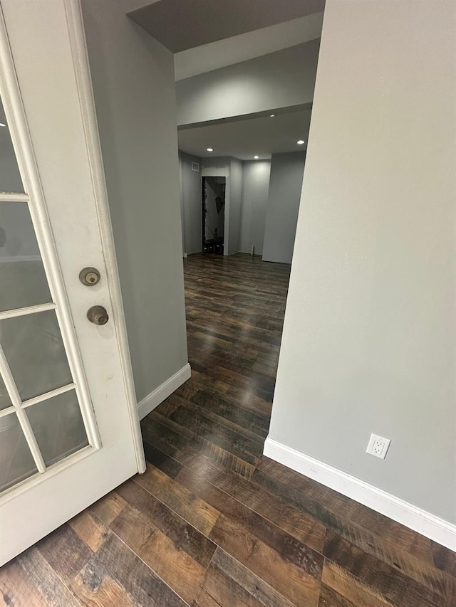 hall featuring baseboards and wood finished floors