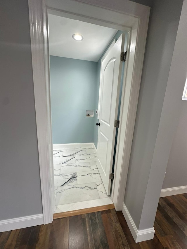 hallway featuring marble finish floor and baseboards