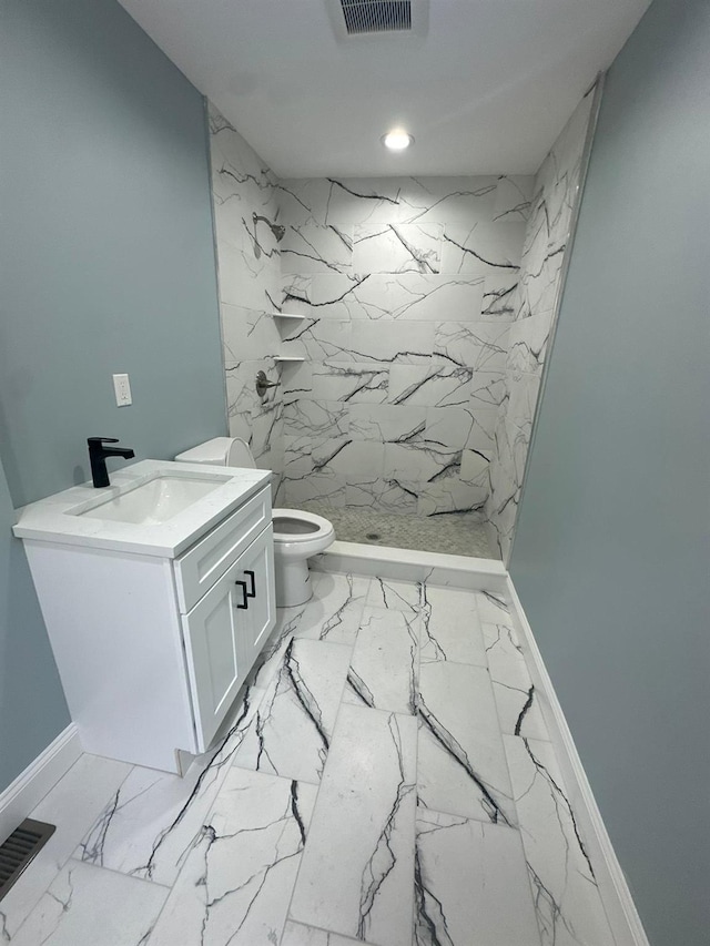 bathroom with baseboards, toilet, marble finish floor, vanity, and a shower stall