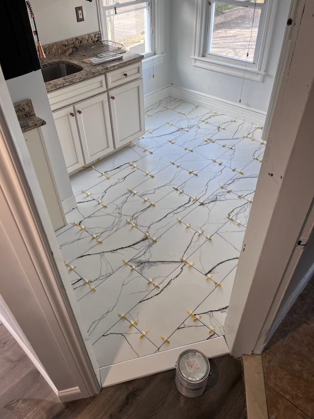 bathroom featuring a healthy amount of sunlight, baseboards, and vanity