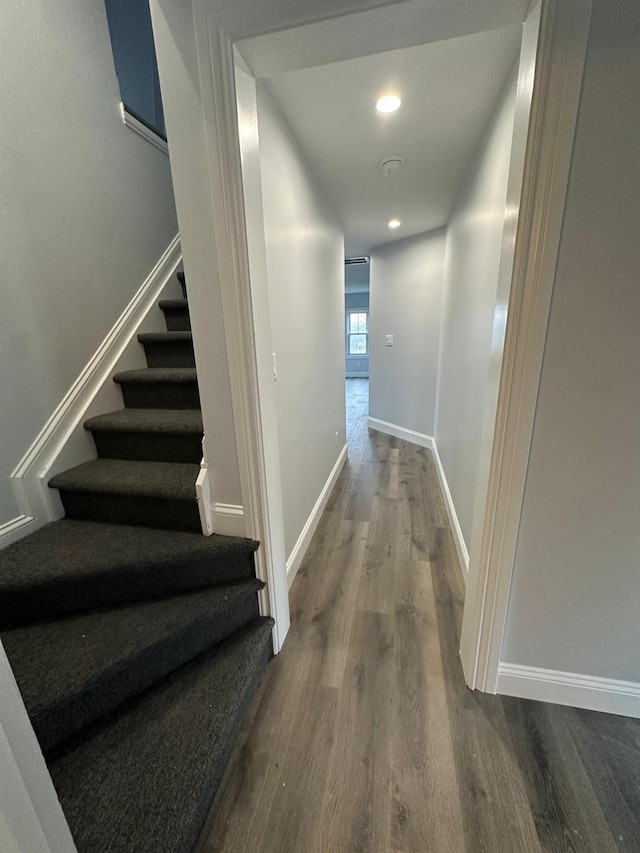 hall with recessed lighting, dark wood finished floors, baseboards, and stairs