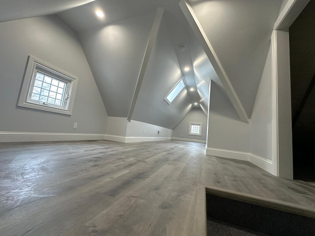 additional living space with lofted ceiling, wood finished floors, and baseboards