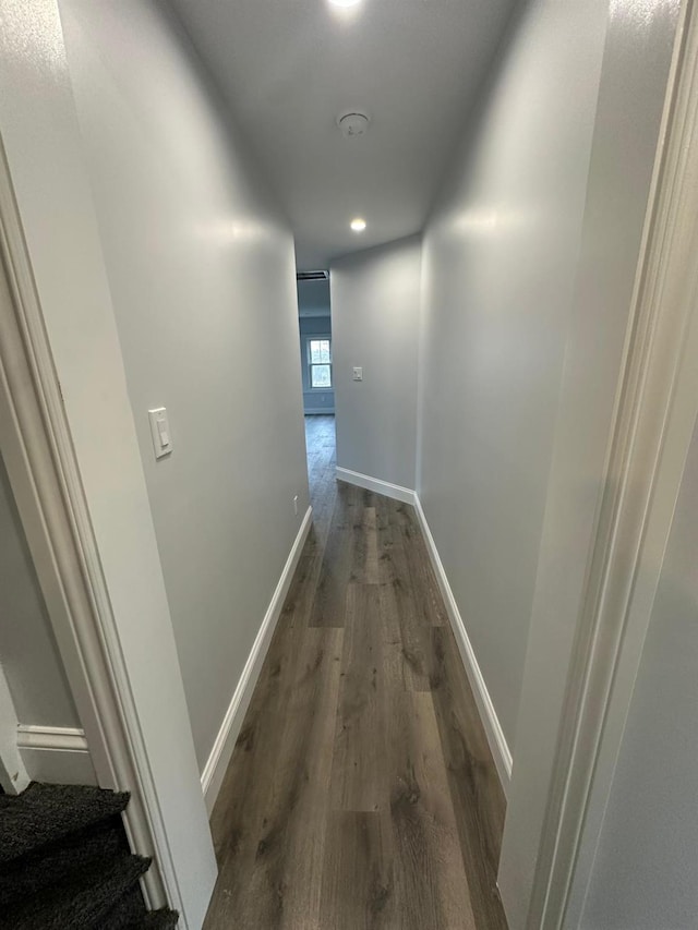 hallway featuring baseboards and dark wood finished floors