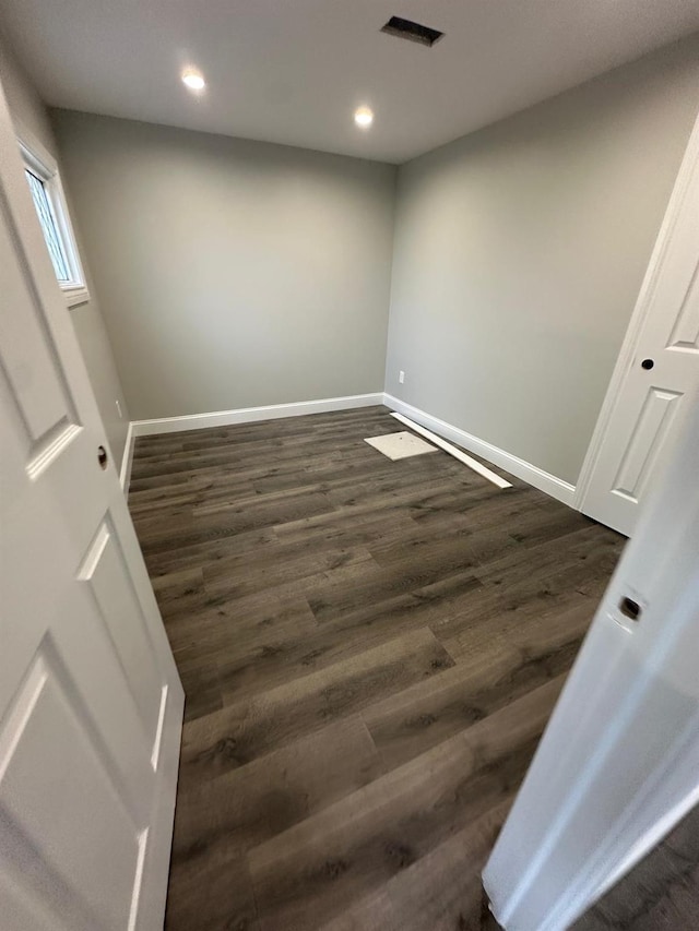 spare room with dark wood-style floors, recessed lighting, visible vents, and baseboards