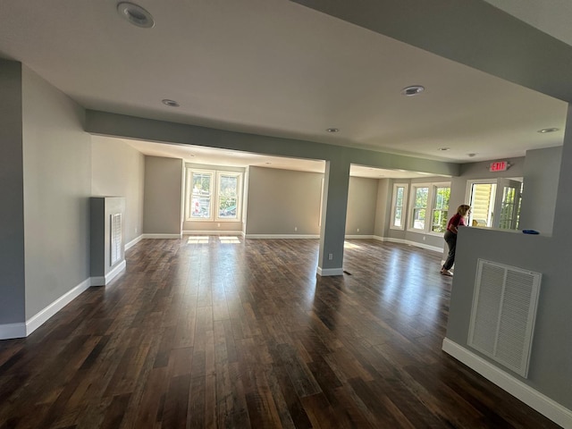 unfurnished living room featuring dark wood-style flooring, recessed lighting, visible vents, and baseboards