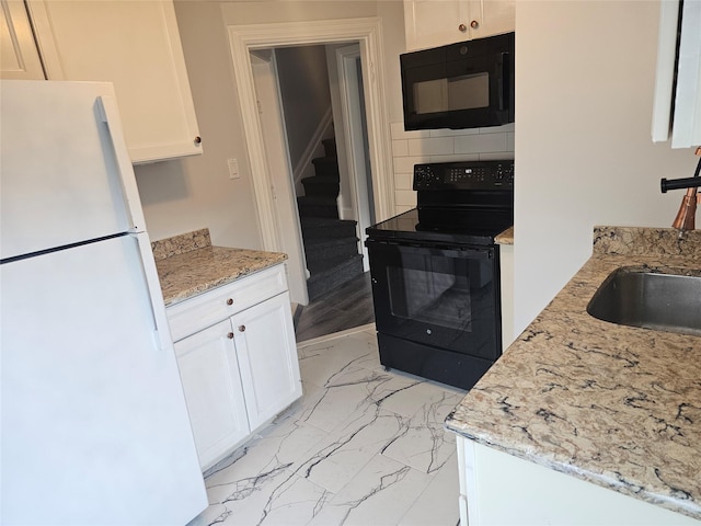 kitchen with white cabinets, a sink, marble finish floor, black appliances, and backsplash