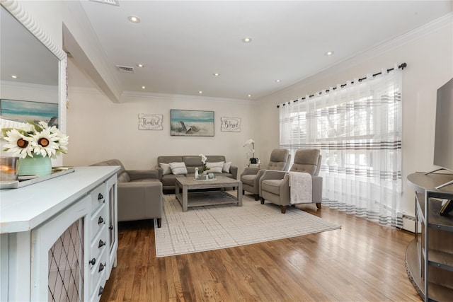 living area with recessed lighting, a baseboard radiator, visible vents, ornamental molding, and wood finished floors