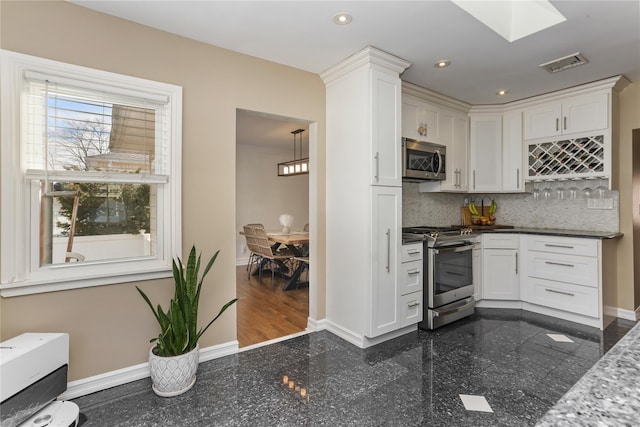 kitchen with granite finish floor, visible vents, stainless steel appliances, and baseboards