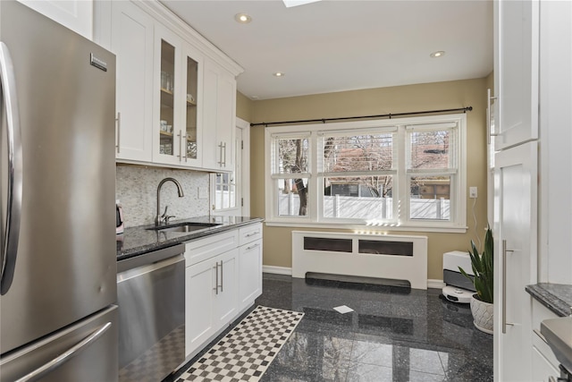 kitchen featuring stainless steel appliances, granite finish floor, a sink, and recessed lighting