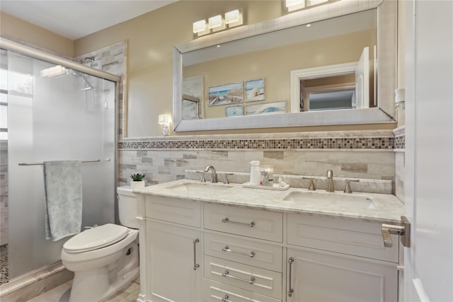 bathroom with tile walls, a sink, a shower stall, and toilet