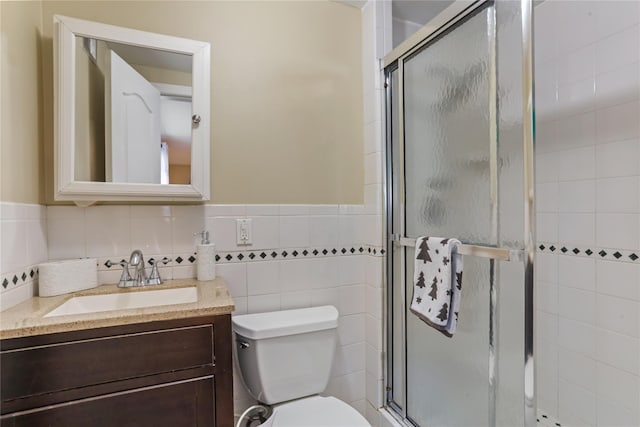 full bathroom with toilet, a stall shower, tile walls, and vanity