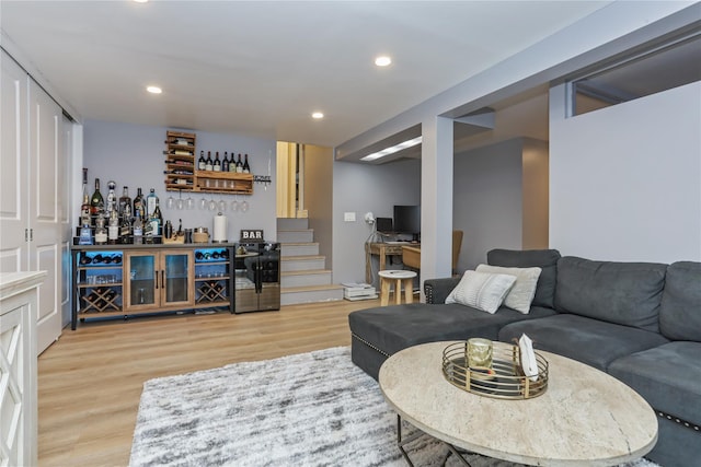 living room featuring light wood finished floors, a bar, stairs, and recessed lighting