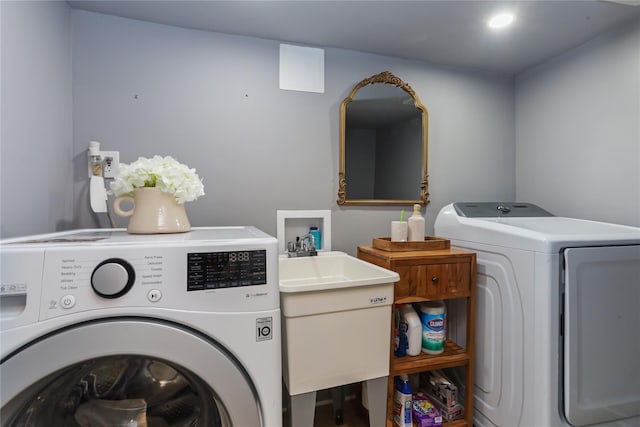 washroom with a sink, laundry area, and washing machine and dryer